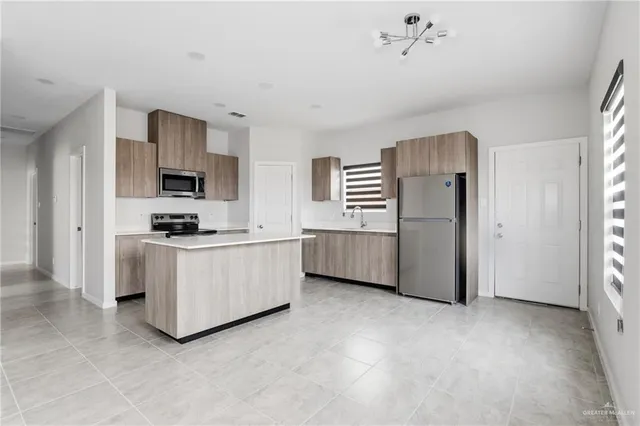 a kitchen with stainless steel appliances a white refrigerator a stove top oven a sink and dishwasher