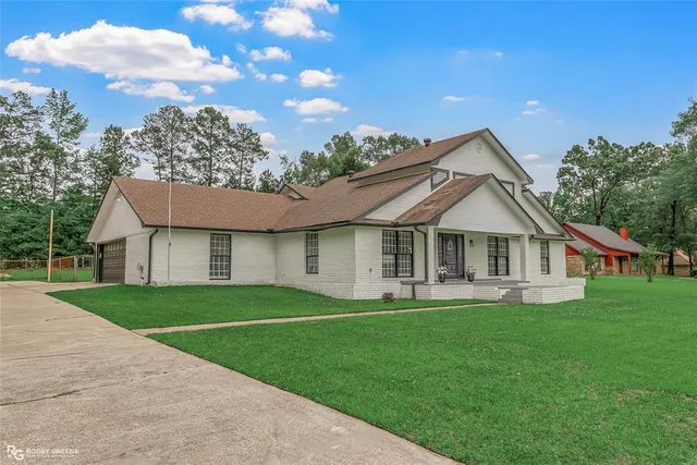 a front view of a house with a yard and trees