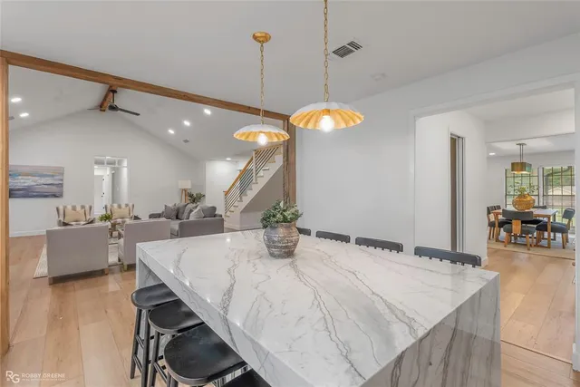 a kitchen with a dining table wooden floor and a chandelier