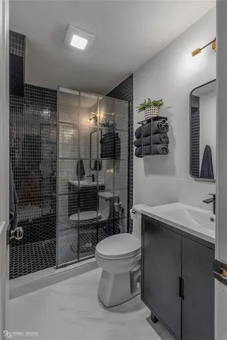 a bathroom with a sink toilet a mirror and shower