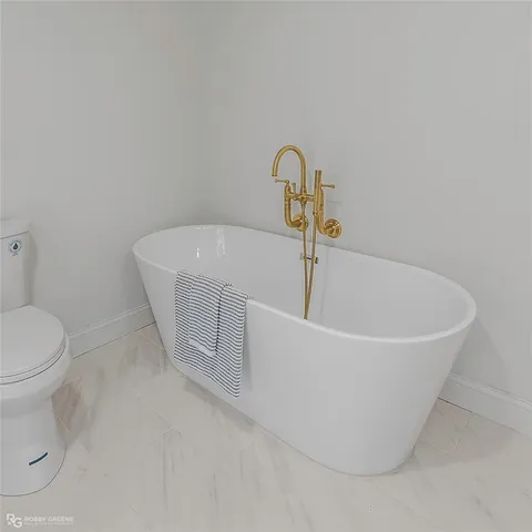 a white bath tub sitting next to a toilet