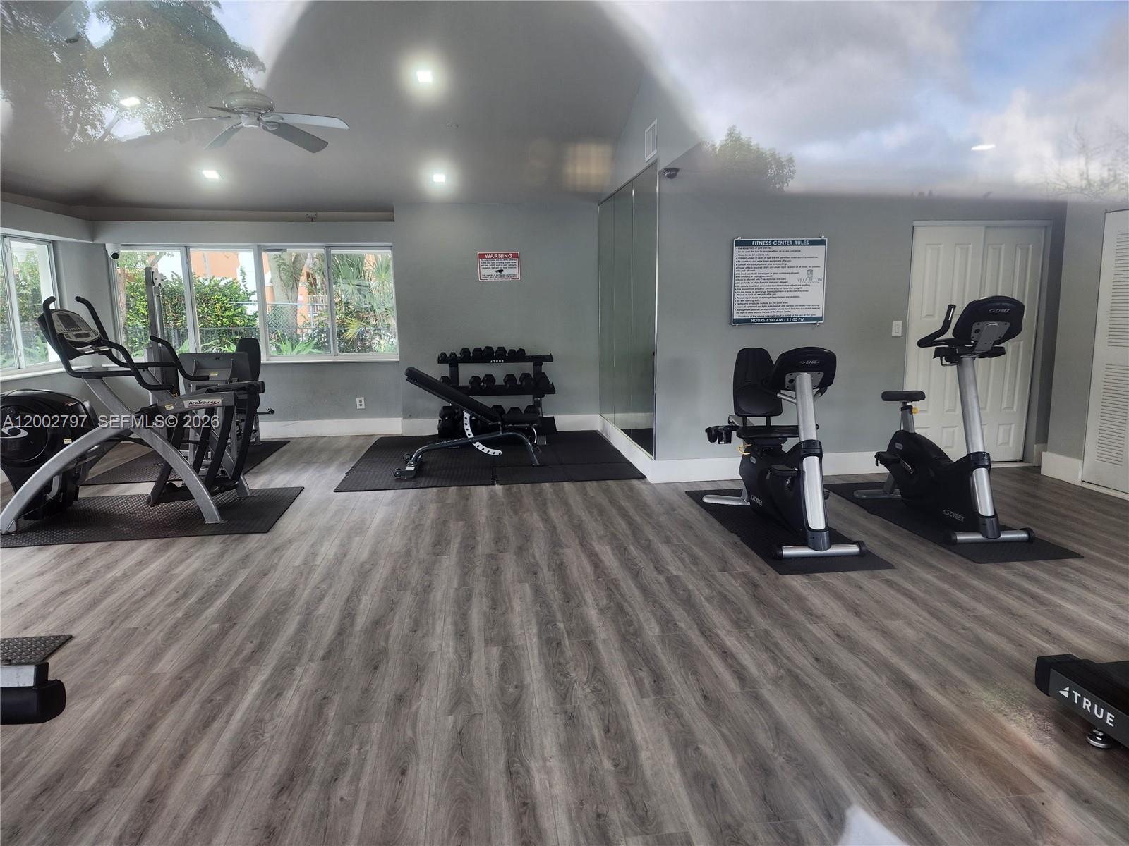 7220 Northwest 179th Street, Unit 111 Hialeah, FL 33015 - Photo 11 of 12 a living room with furniture and a wooden floor