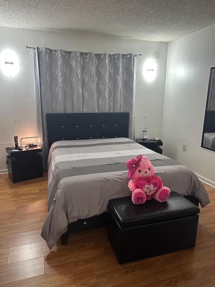 7220 Northwest 179th Street, Unit 111 Hialeah, FL 33015 - Photo 2 of 12 a bedroom with a bed and window