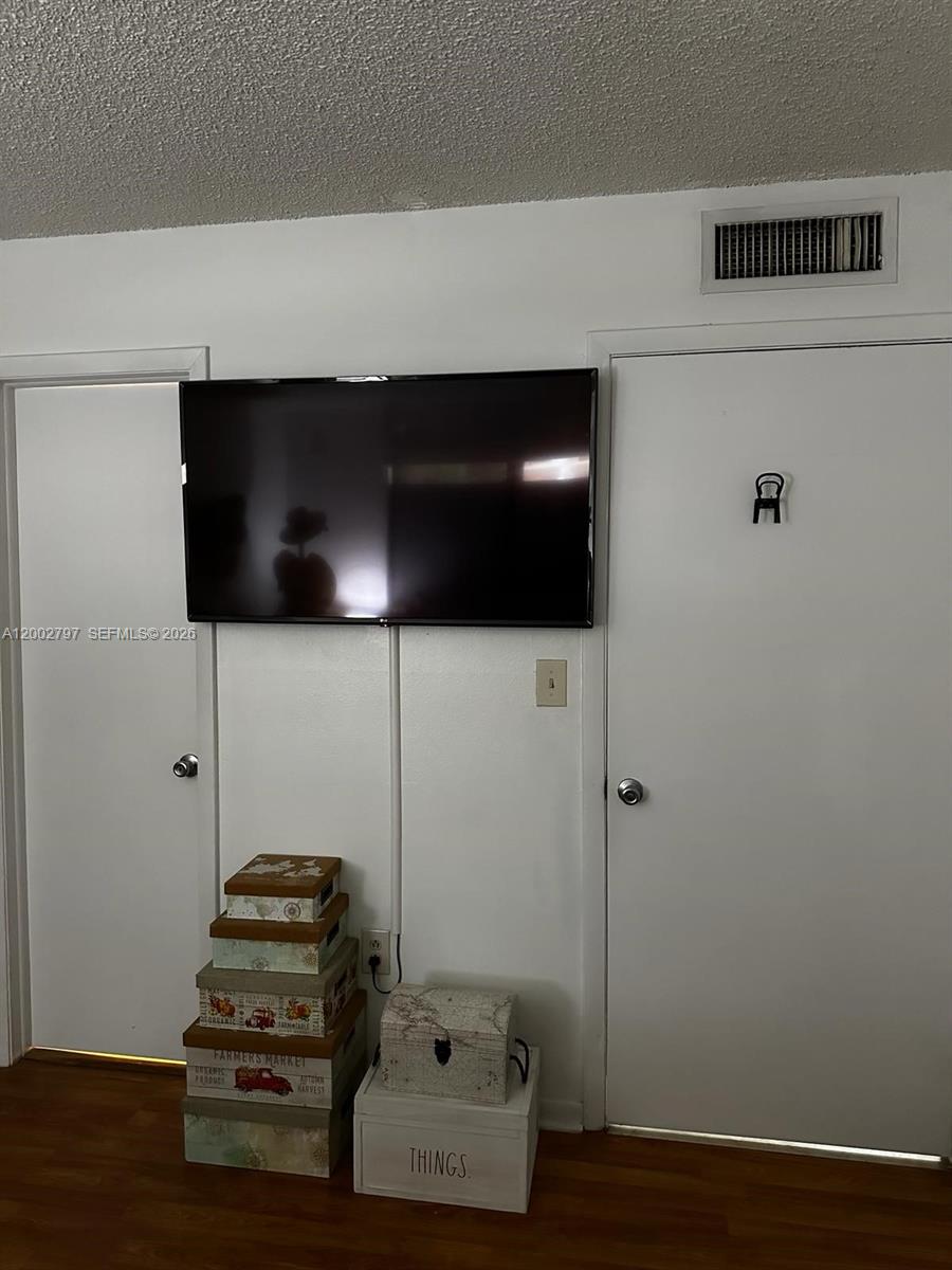 7220 Northwest 179th Street, Unit 111 Hialeah, FL 33015 - Photo 3 of 12 a room with a flat screen tv and a potted plant