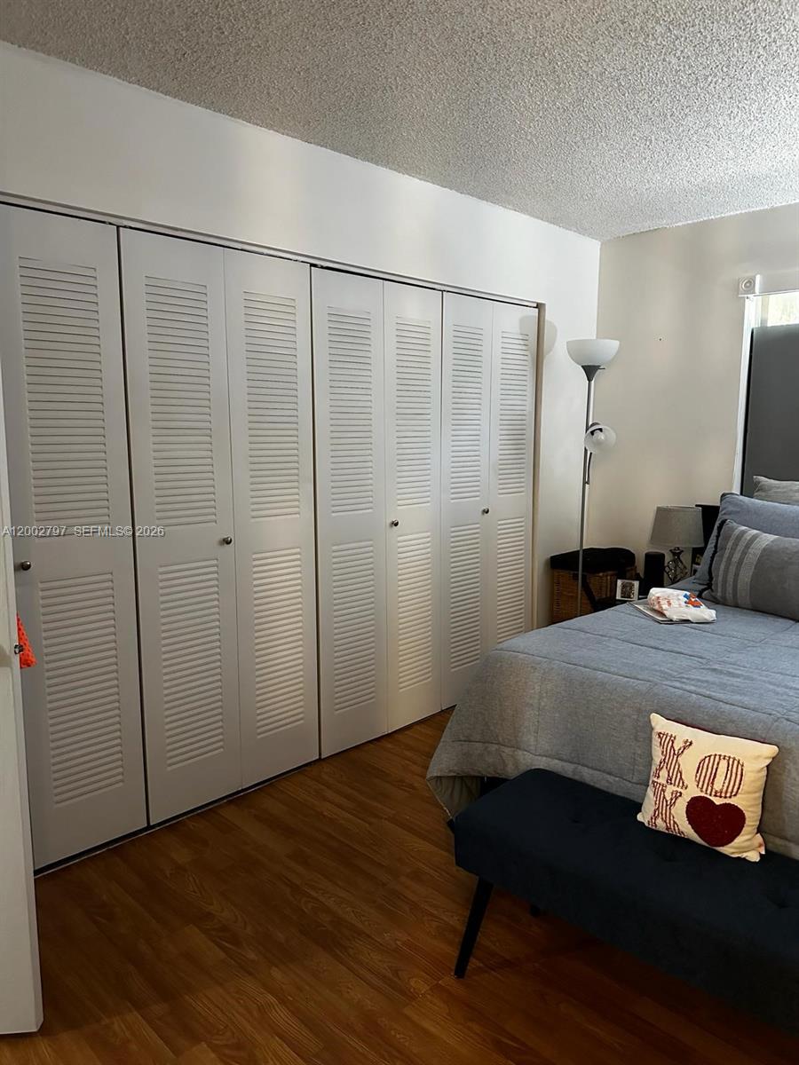 7220 Northwest 179th Street, Unit 111 Hialeah, FL 33015 - Photo 4 of 12 a bedroom with a bed and a mirror