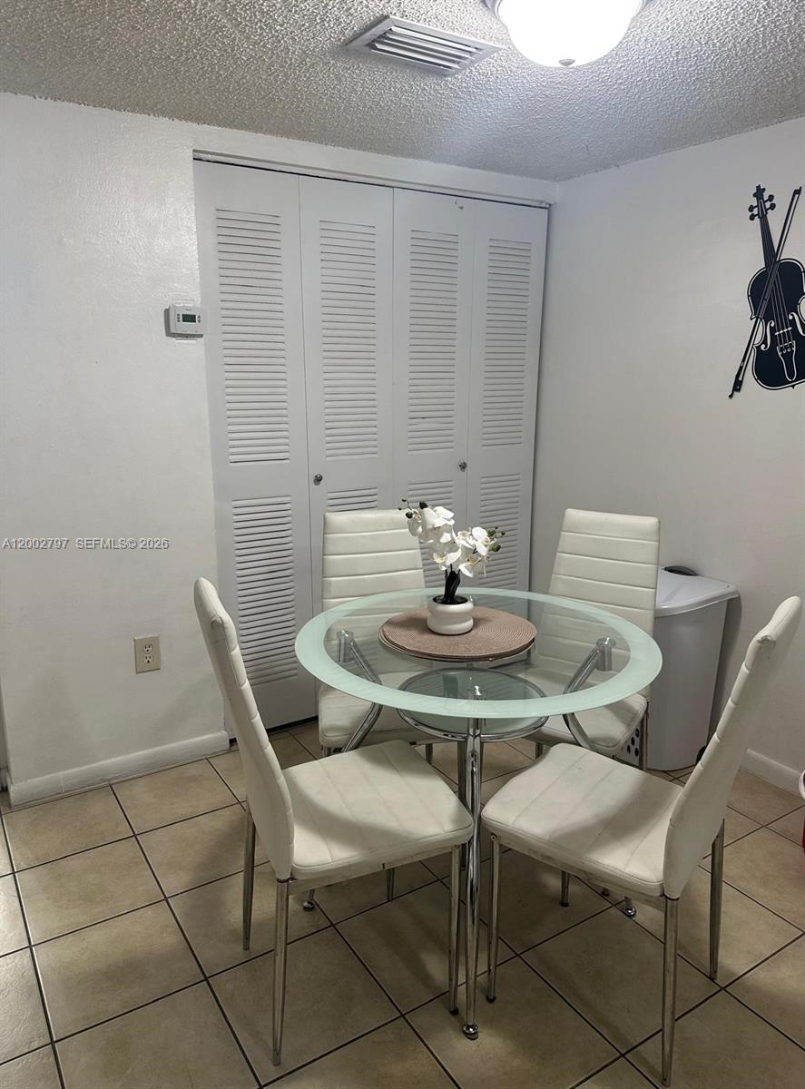 7220 Northwest 179th Street, Unit 111 Hialeah, FL 33015 - Photo 6 of 12 a view of a dining room that has a table and chairs in it