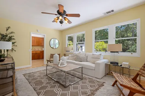 a living room with furniture a chandelier and a window