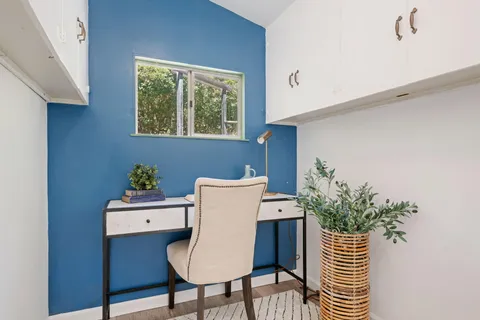 a view of a workspace with furniture and a potted plant