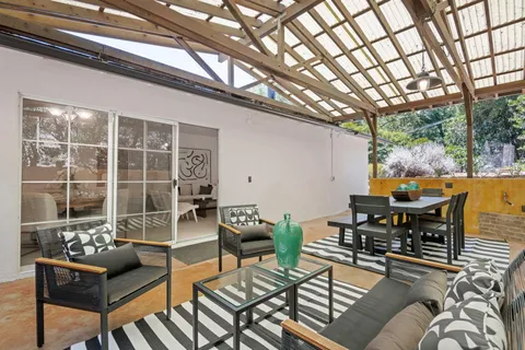 a patio with patio couches table and chairs and potted plants