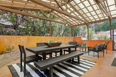 a view of a patio with couple of chairs and a table and chairs