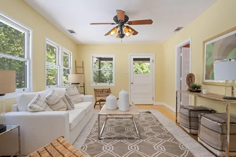 a living room with furniture fireplace and a large window