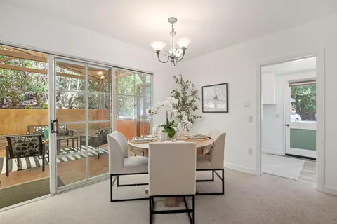 a living room with furniture a chandelier and a dining table