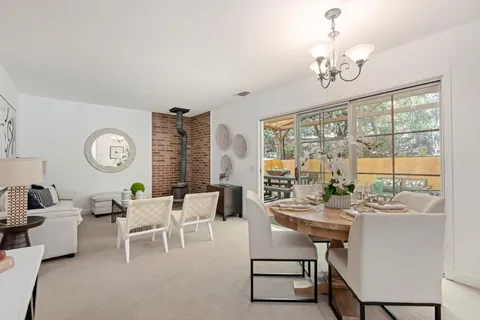 a very nice looking dining room with furniture a chandelier and a large window