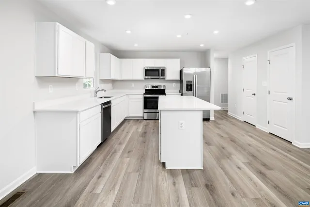 a large kitchen with a sink and a stove top oven