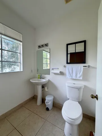 a bathroom with a toilet sink and mirror