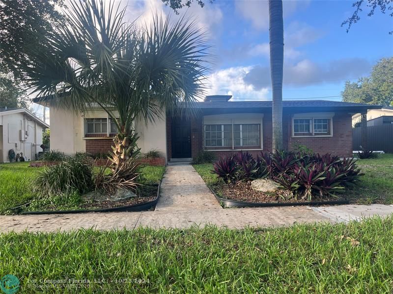 3322 Coolidge Street Hollywood, FL 33021 - Photo 1 of 32 a front view of a house with a garden