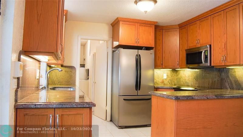 3322 Coolidge Street Hollywood, FL 33021 - Photo 6 of 32 a kitchen with granite countertop a refrigerator and a sink