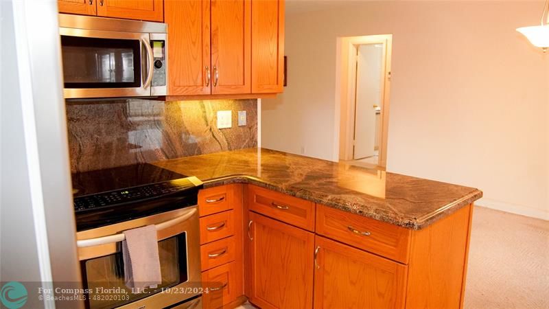 3322 Coolidge Street Hollywood, FL 33021 - Photo 8 of 32 a kitchen with stainless steel appliances granite countertop a stove a sink and a microwave