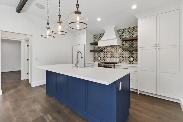 a kitchen with a sink a refrigerator and chairs