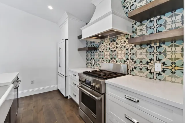 a kitchen with a stove and a wooden floor