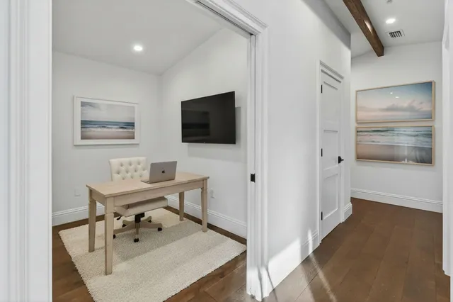 a view of a workspace with furniture and wooden floor