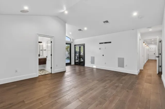an empty room with wooden floor and white walls