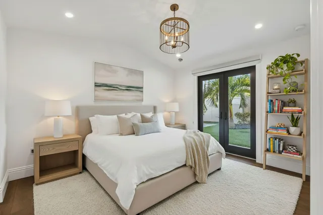 an empty room with wooden floor and chandelier