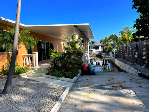 a view of a patio with table and chairs potted plants and large tree