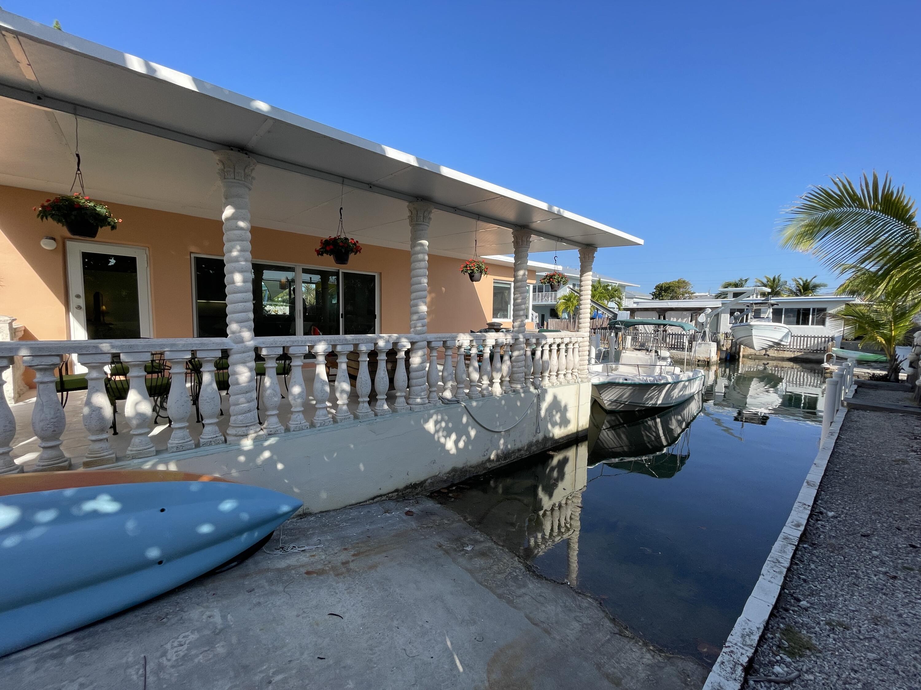 64 Seagate Boulevard Key Largo, FL 33037 - Photo 23 of 44 a view of a patio with dining table and chairs