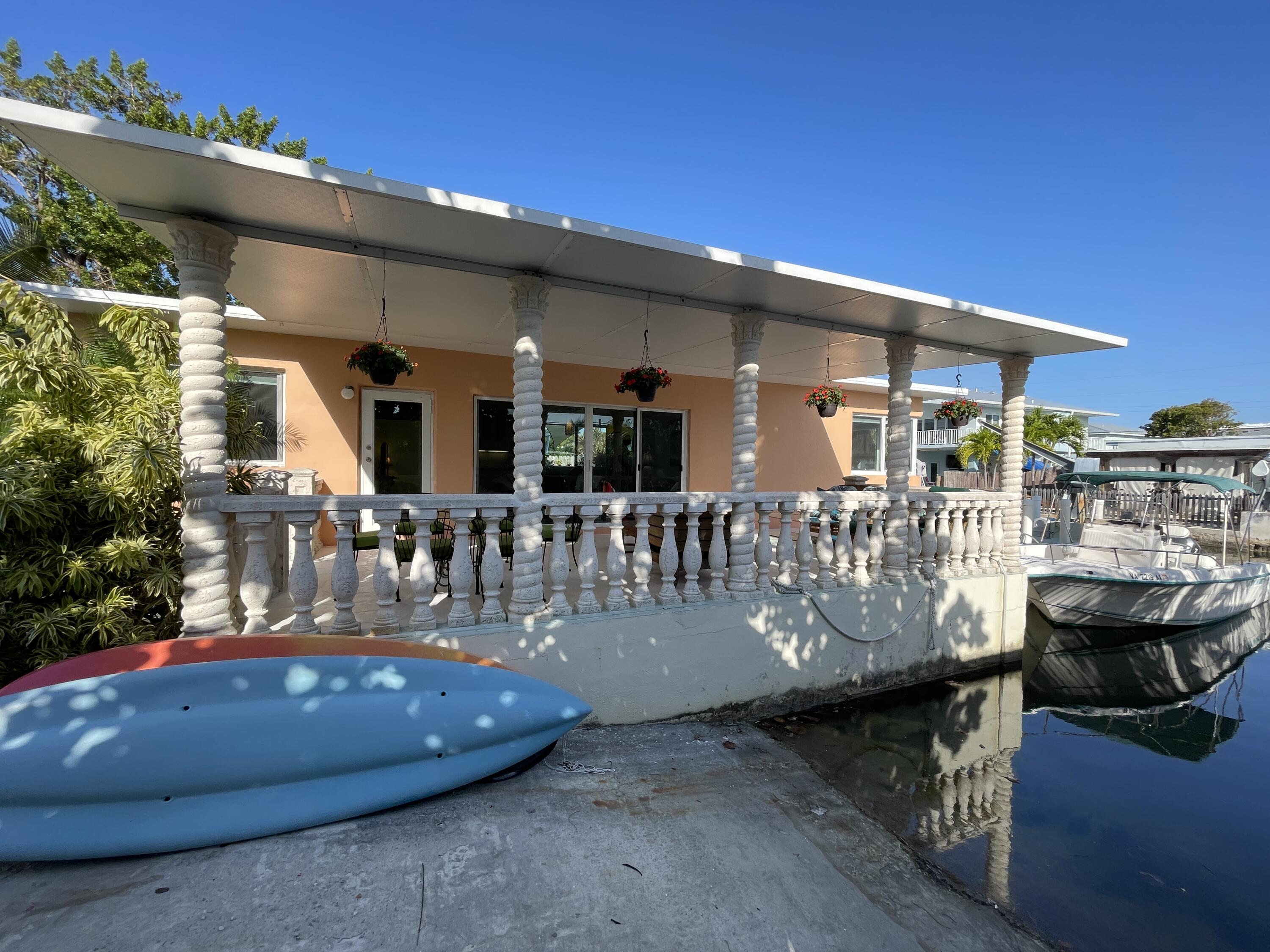 64 Seagate Boulevard Key Largo, FL 33037 - Photo 3 of 44 a view of a patio with table and chairs potted plants and large tree