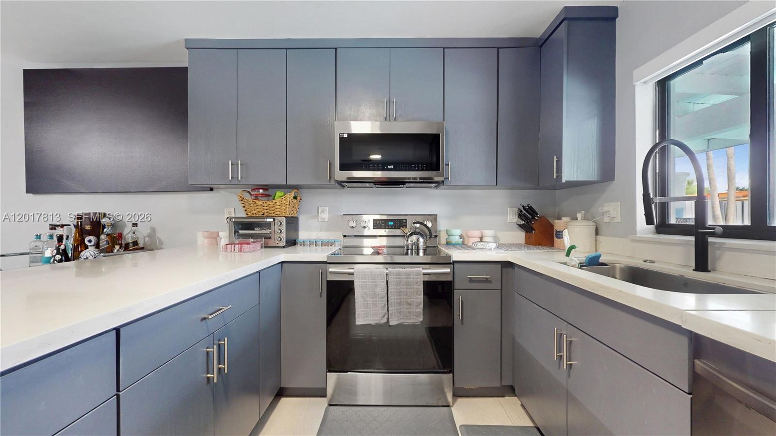 12535 Southwest 31st Terrace Miami, FL 33175 - Photo 11 of 32 a kitchen with a sink white cabinets and black stainless steel appliances