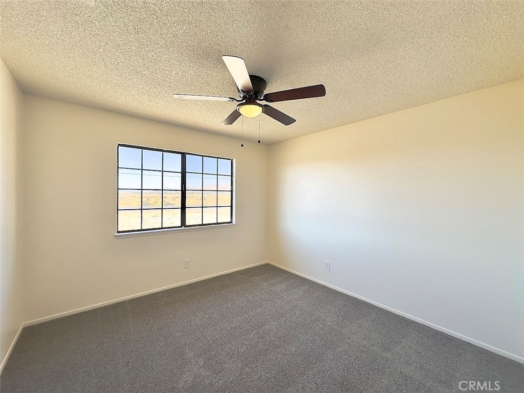 22311 Thunderbird Road Apple Valley, CA 92307 - Photo 13 of 18 an empty room with a window and a fan