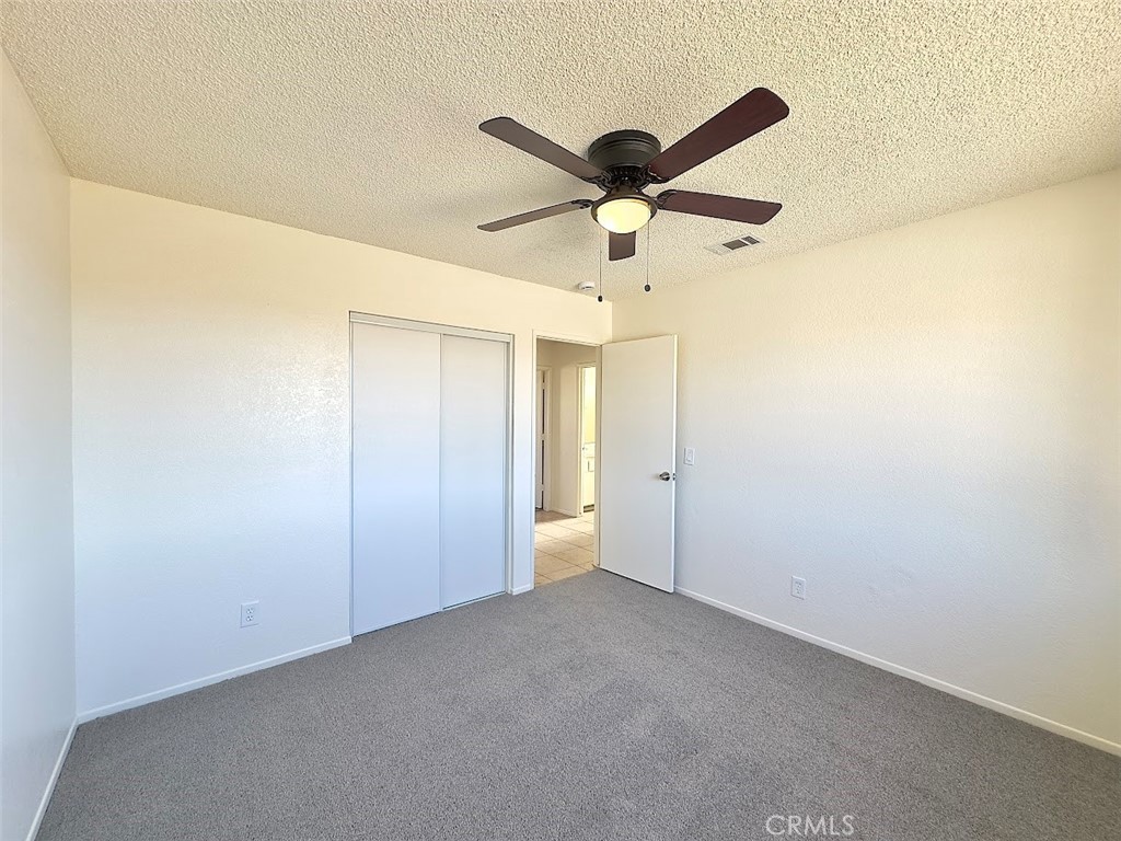 22311 Thunderbird Road Apple Valley, CA 92307 - Photo 14 of 18 an empty room with a ceiling fan and a fan