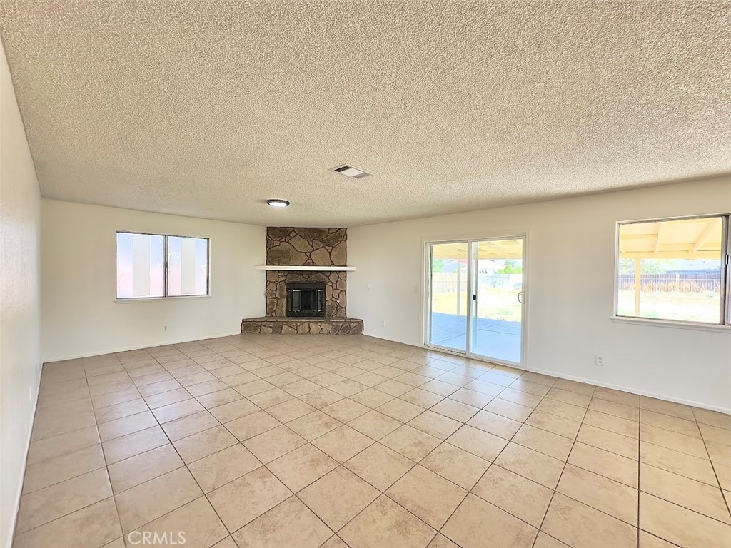22311 Thunderbird Road Apple Valley, CA 92307 - Photo 5 of 18 a view of empty room with a fireplace and window