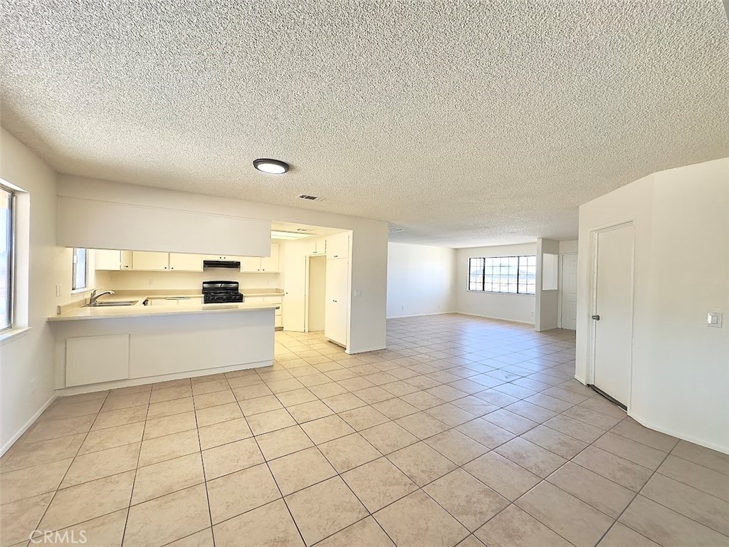 22311 Thunderbird Road Apple Valley, CA 92307 - Photo 7 of 18 a large white kitchen with a stove a sink dishwasher and a refrigerator with white cabinets