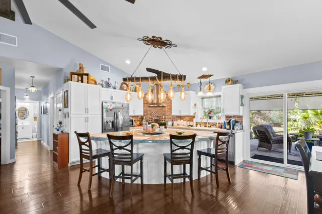 a view of a kitchen and dining room with furniture a chandelier and wooden floor