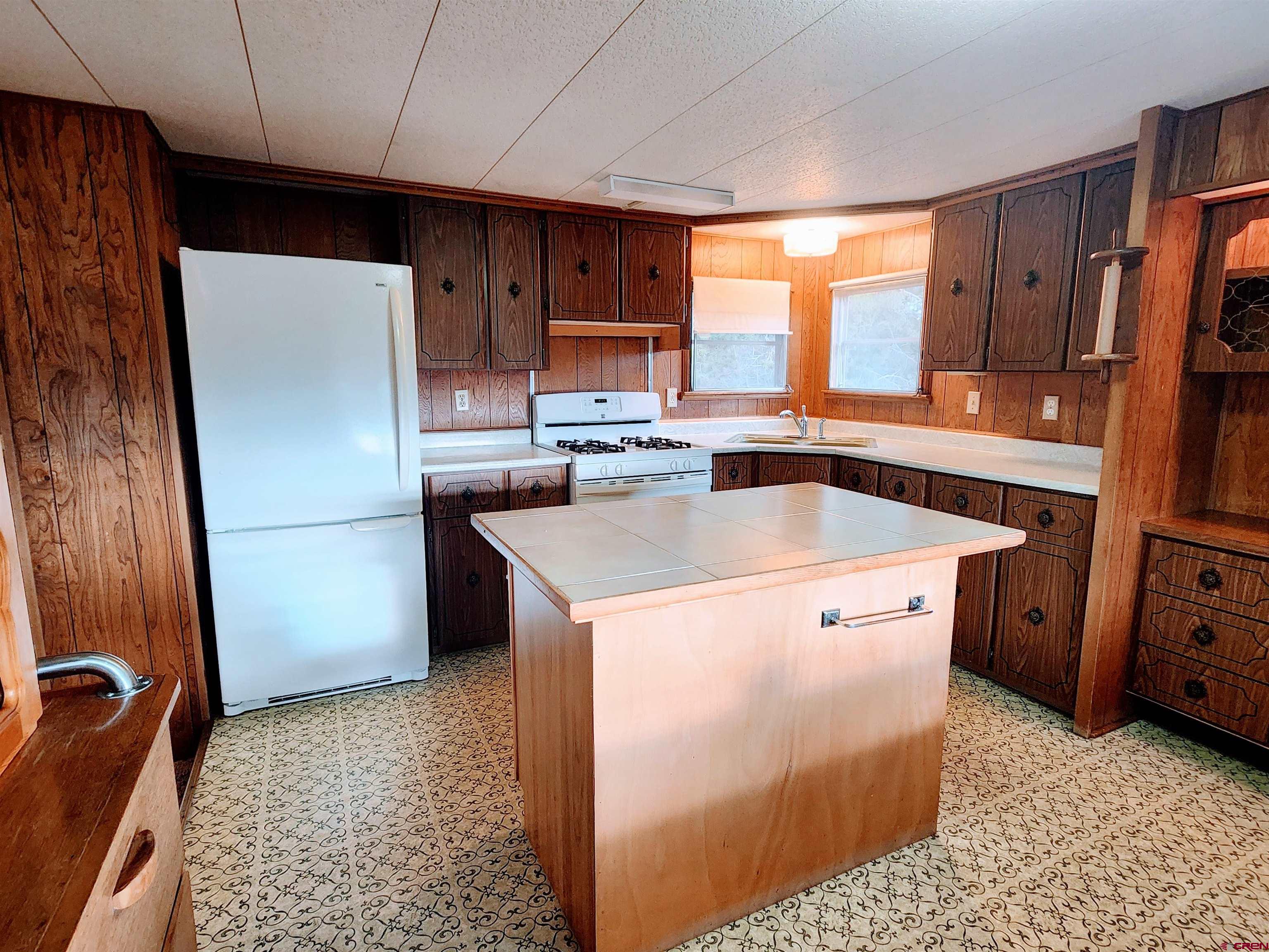 24593 Timothy Road Cedaredge, CO 81413 - Photo 17 of 33 a kitchen with a refrigerator sink and cabinets