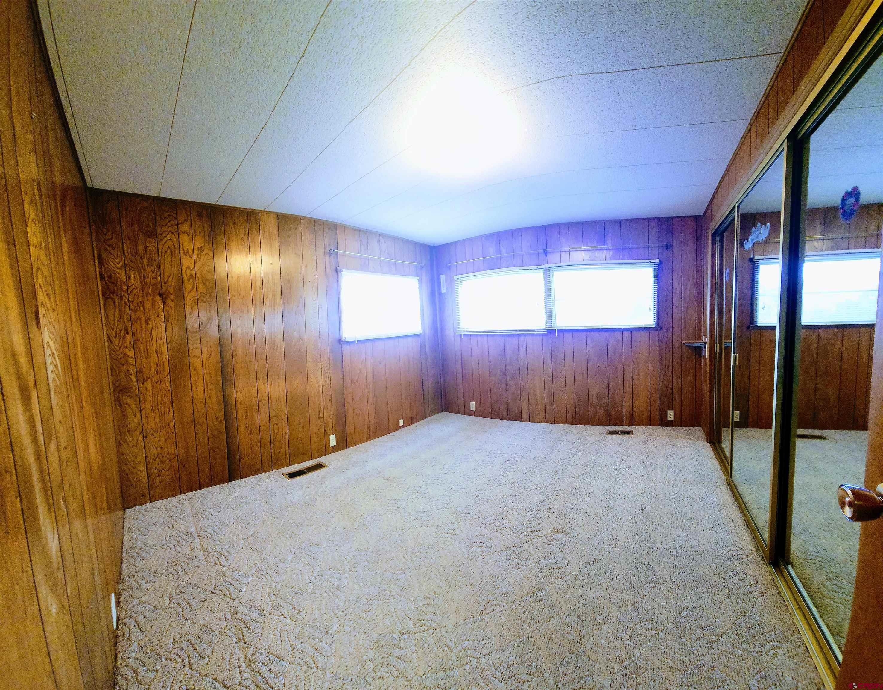 24593 Timothy Road Cedaredge, CO 81413 - Photo 23 of 33 a view of an empty room with wooden floor and windows