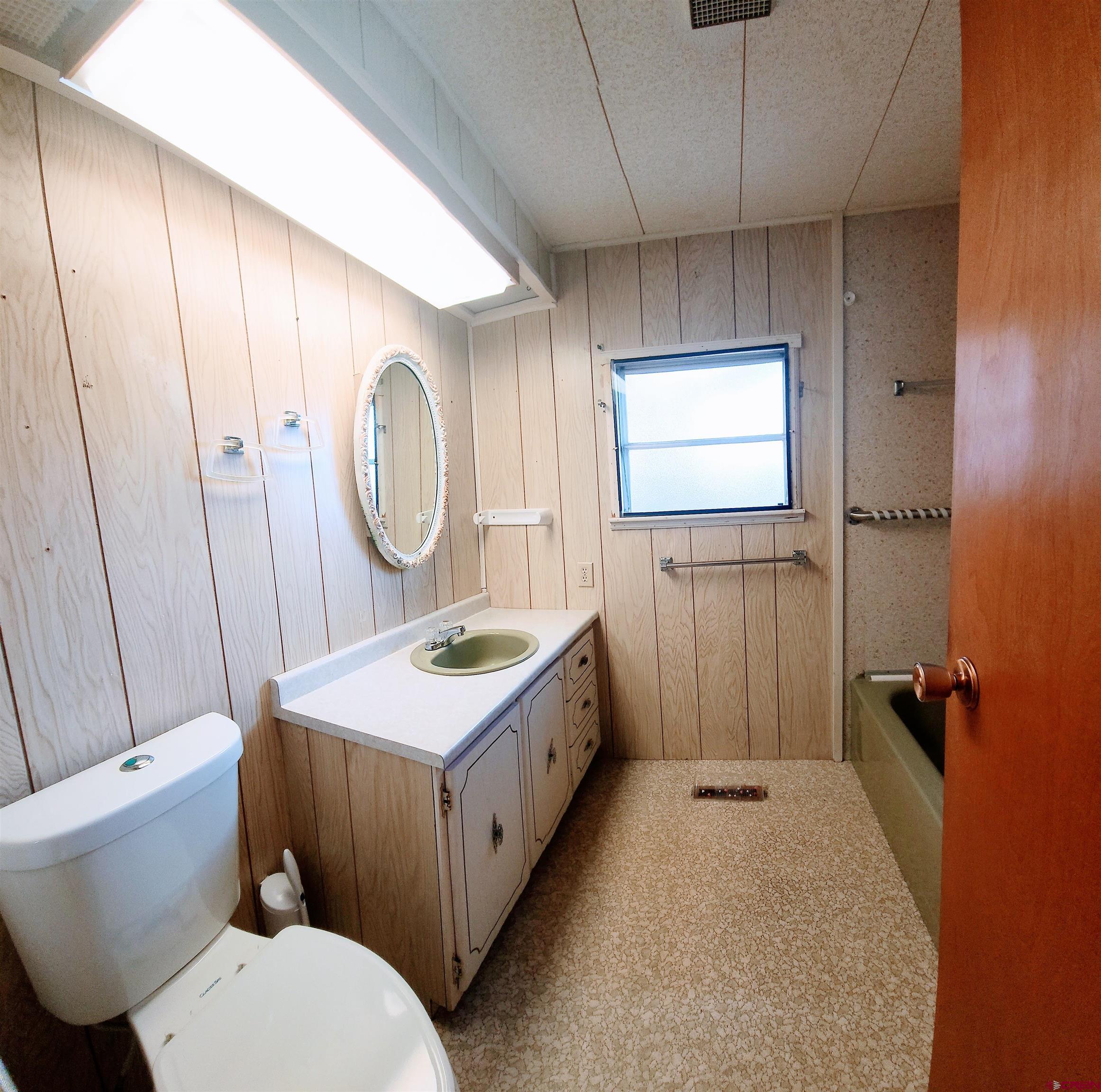 24593 Timothy Road Cedaredge, CO 81413 - Photo 25 of 33 a bathroom with a sink a toilet and mirror
