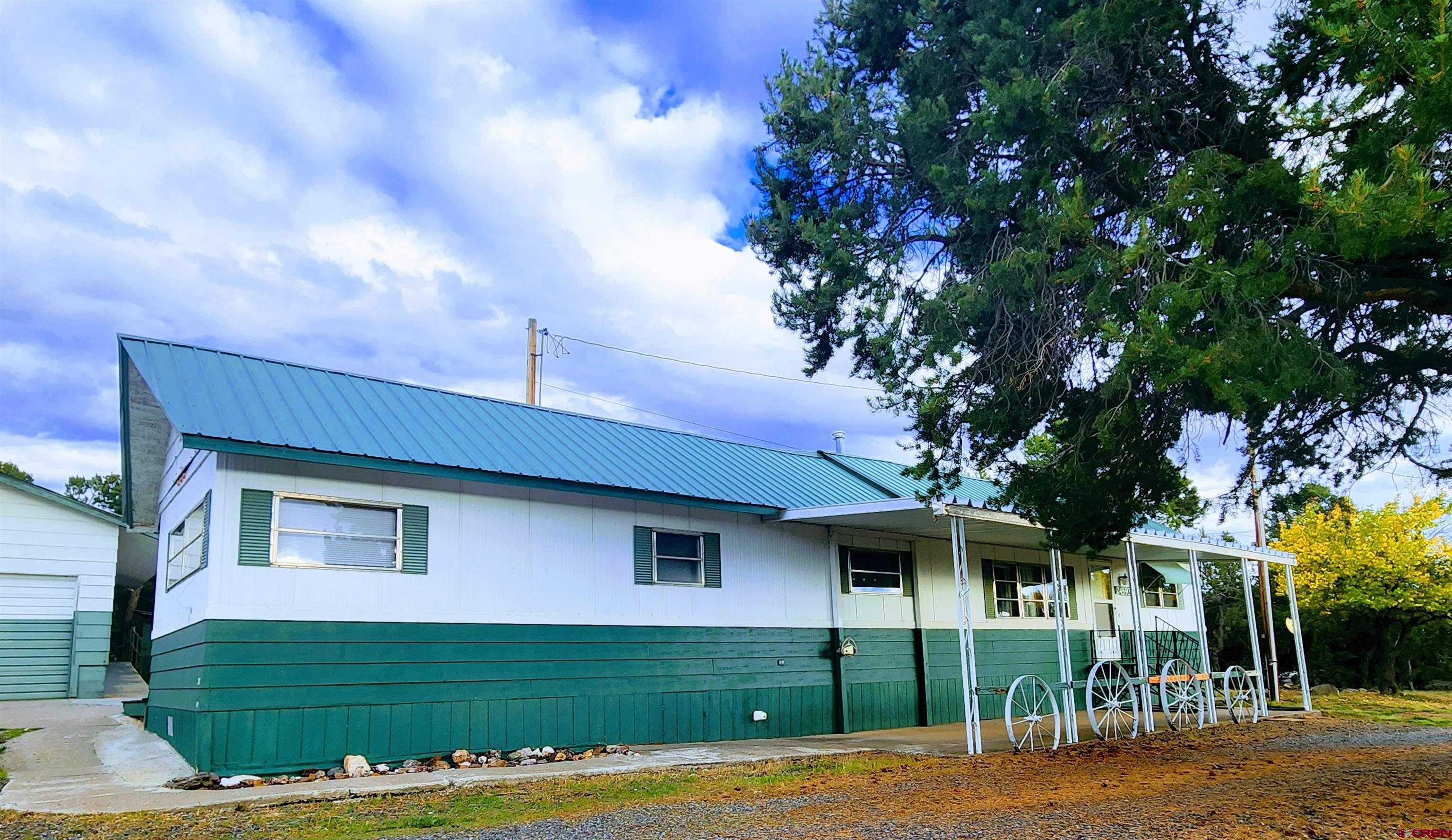 24593 Timothy Road Cedaredge, CO 81413 - Photo 4 of 33 a front view of a house with a yard