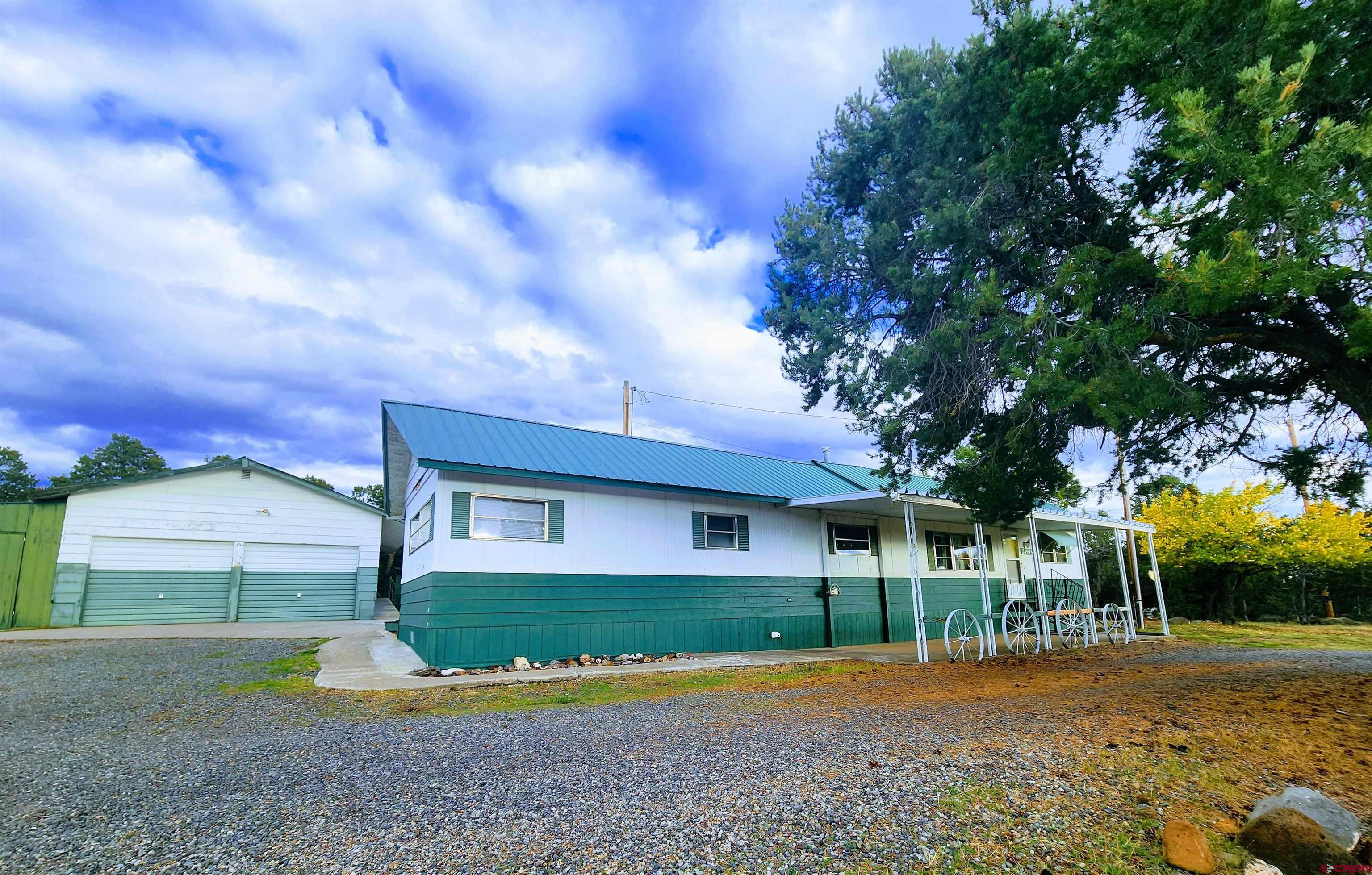 24593 Timothy Road Cedaredge, CO 81413 - Photo 5 of 33 a front view of a house with a yard and garage