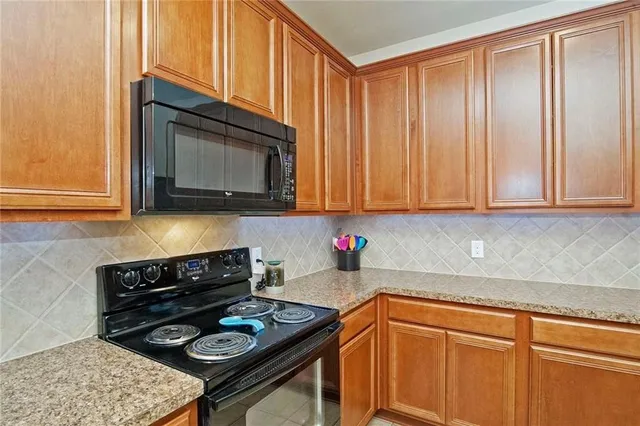 a kitchen with stainless steel appliances granite countertop a stove a sink dishwasher and cabinets with wooden floor