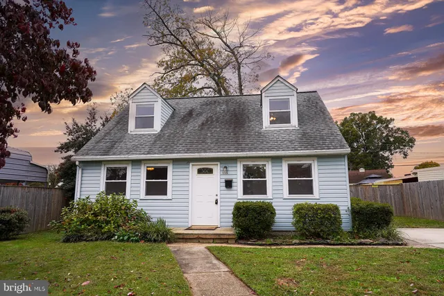 a front view of a house with a yard and potted plants
