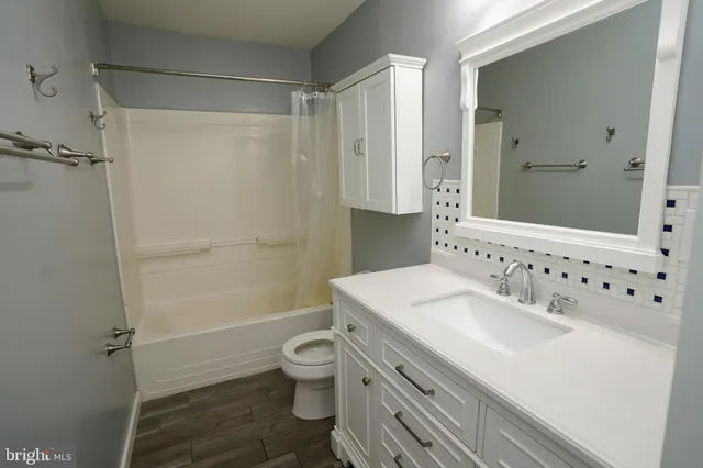 a bathroom with a sink toilet vanity and shower