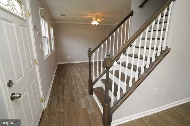 a view of staircase with wooden floor and white walls
