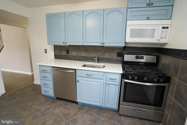 a kitchen with white cabinets and white appliances