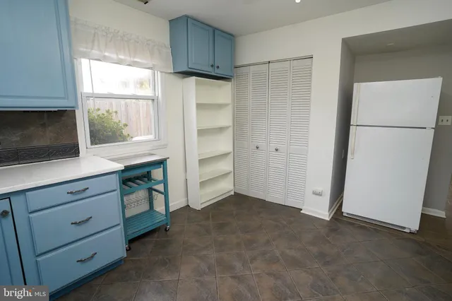 a kitchen with white cabinets and window