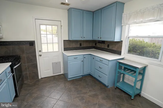 a kitchen with white cabinets and a stove top oven