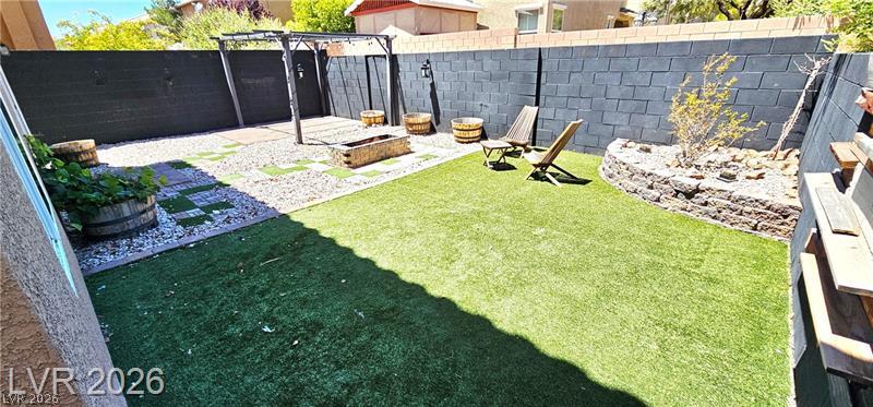6302 Jackson Spring Road Las Vegas, NV 89118 - Photo 44 of 48 A well-appointed yard features artificial turf, a fire pit, and durable block wall fencing.