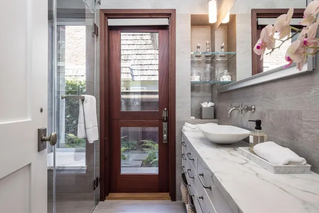 a bathroom with a granite countertop sink a toilet and a shower